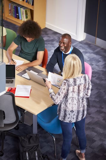 Adult woman sharing reports with 2 colleagues